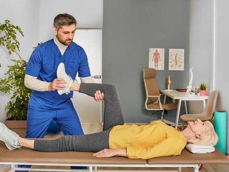 Physiotherapist guiding a patient through gentle knee exercises